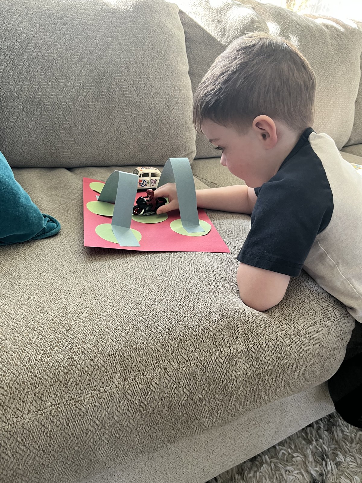 Child playing with paper arch craft from Busy Bees session