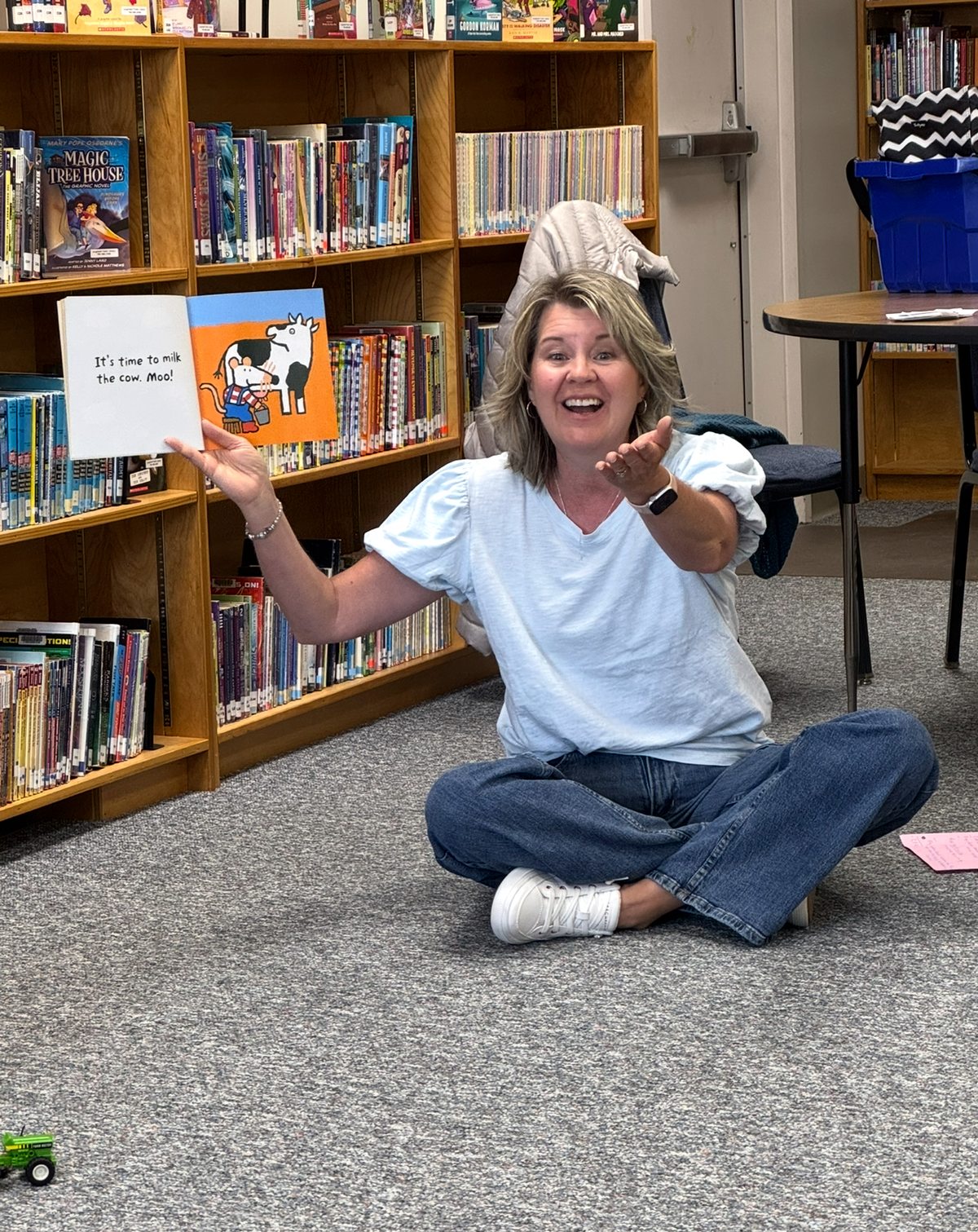 Joanne enthusiastically reading a picture book to children